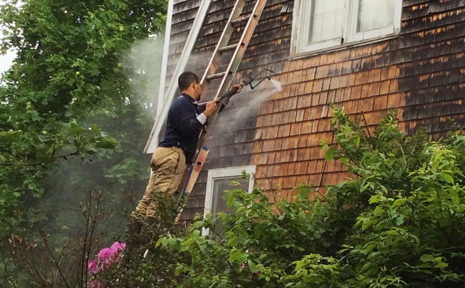 Nice Mobile Washing power washing a home on a ladder